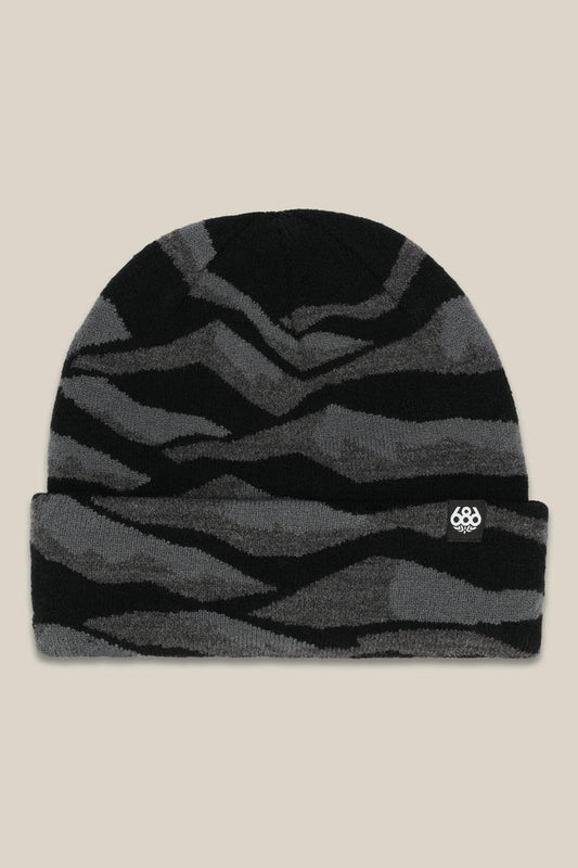 The 686 Summit Beanie by 686 features a black and dark gray wavy striped design with a small white logo patch on the folded brim, shown on a beige background‚Äîideal for adventurous climbs or epic descents.