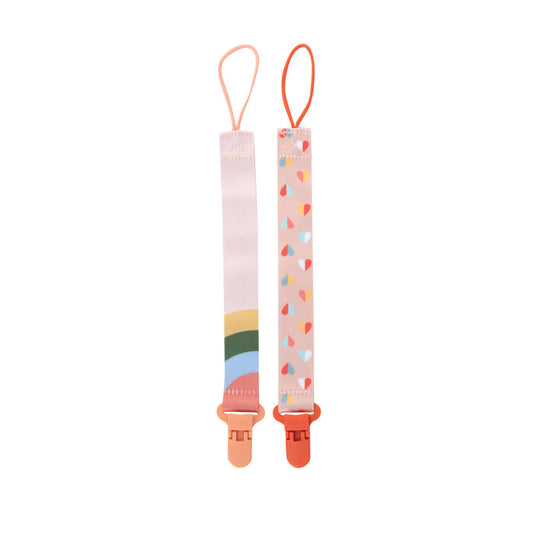 The Cloth Pacifier Clip (2 Pack) features one rainbow and one multicolored hearts design. Each has a loop at the top and a pink clip at the bottom to keep your baby's pacifier secure and add a stylish touch.