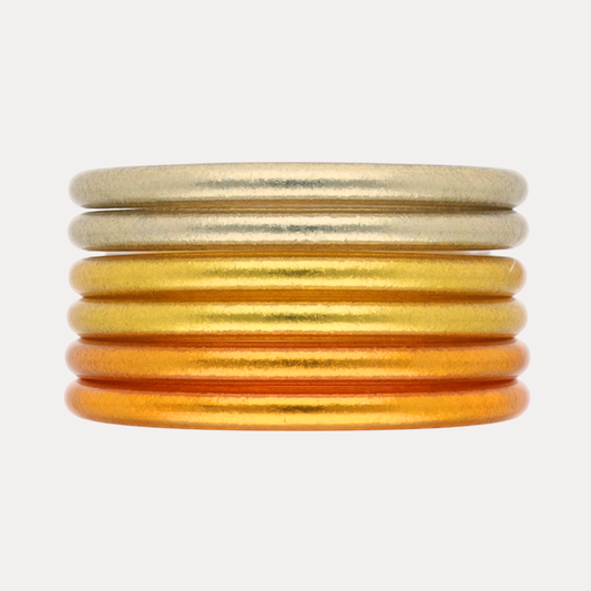 Golden Core Mixed Stack featuring gold and orange bangles stacked together for a radiant accessory.