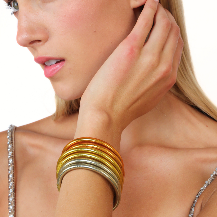Close-up of a model wearing the Golden Core Mixed Stack bangles in vibrant colors on her wrist.