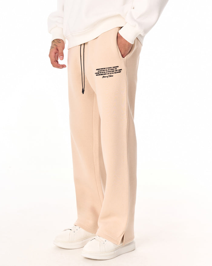Martin Valen MV beige baggy sweatpants side close-up showing front pocket, black drawstring and small printed text