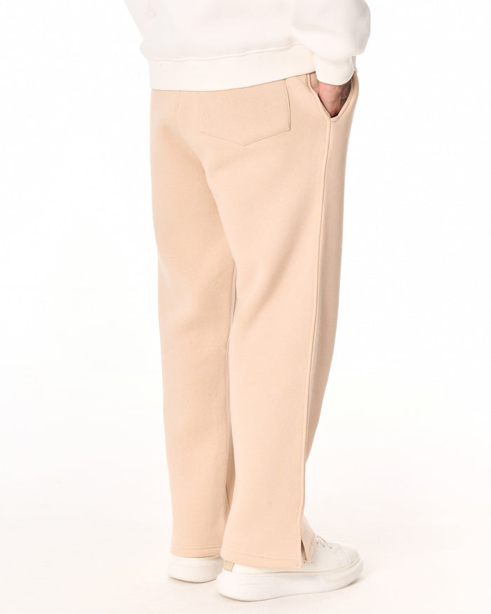 Martin Valen MV beige baggy sweatpants full-leg front view showing side hem slit and white sneakers
