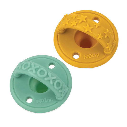 The Sili Soother Pacifier (2 Pack) includes one yellow pacifier with star shapes and one teal pacifier with XOXOXO text, both round, each with three holes and a top handle.